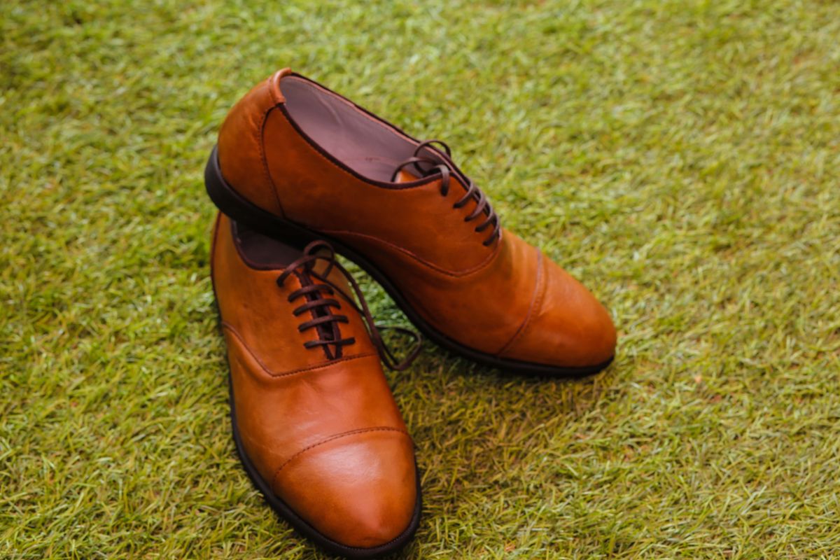Brown leather Sperry boat shoes on green grass